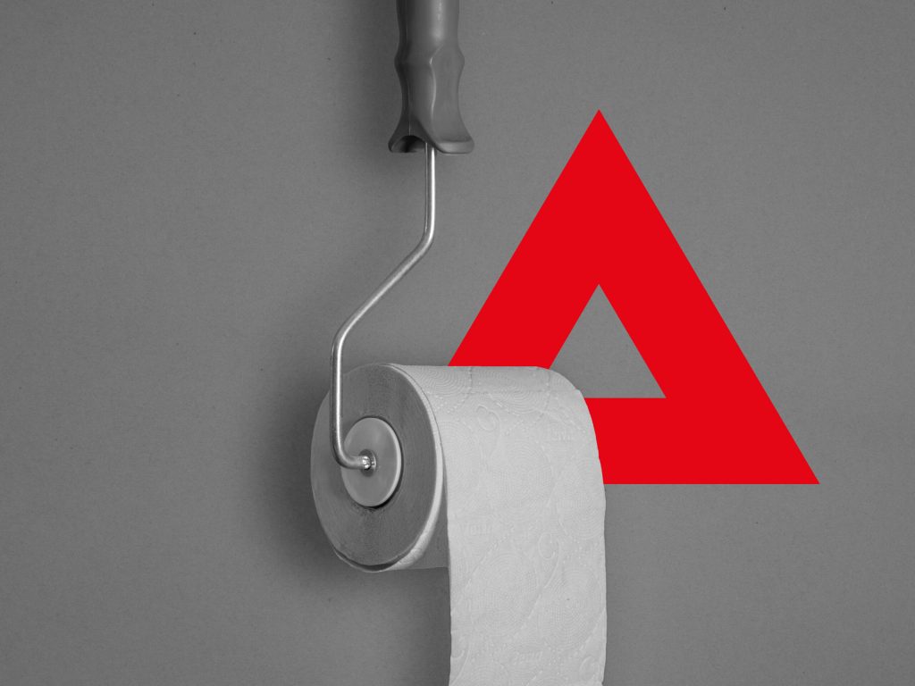 Eine Toilettenpapierrolle mit einem roten Dreieck darauf.