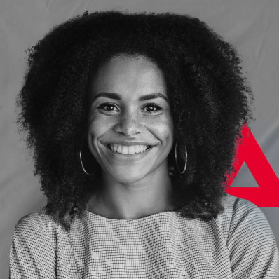 Eine Frau mit lockigen Haaren lächelt vor einem roten Dreieck.