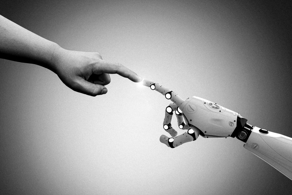 Ein Roboter greift nach einer menschlichen Hand.