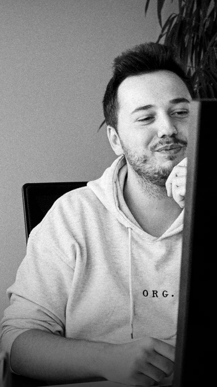 Ein Schwarz-Weiß-Foto eines BCxP-Mitarbeiters, der an einem Computer sitzt.