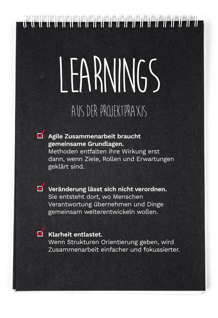 Schwarzes Notizbuch mit der Überschrift ‚Learnings aus der Projektpraxis‘. Darunter drei hervorgehobene Aussagen mit Häkchen: Agile Zusammenarbeit braucht gemeinsame Grundlagen, Veränderung lässt sich nicht verordnen und Klarheit entlastet. Das Bild steht für Erkenntnisse aus dem agilen Projektalltag.