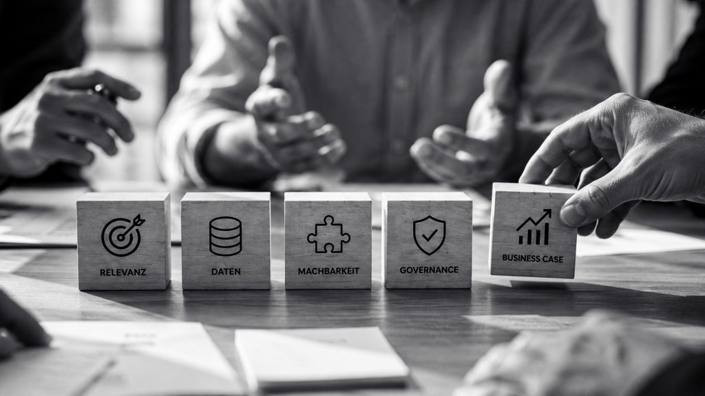 Vier Personen an einem Tisch besprechen fünf Holzklötze mit den Aufschriften „Relevanz“, „Daten“, „Machbarkeit“, „Governance“ und „Business Case“, die jeweils mit einem entsprechenden Symbol versehen sind.